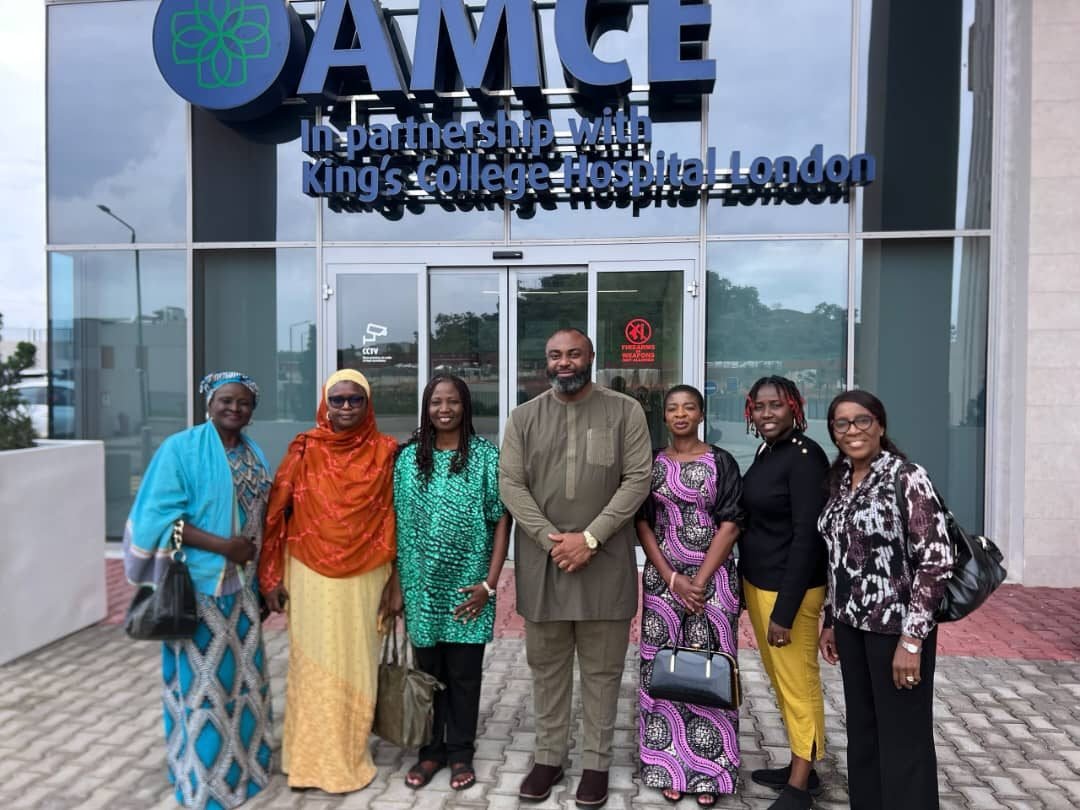 MHFCO team members with a host outside the Africa Medical Centre of Excellence, Abuja
