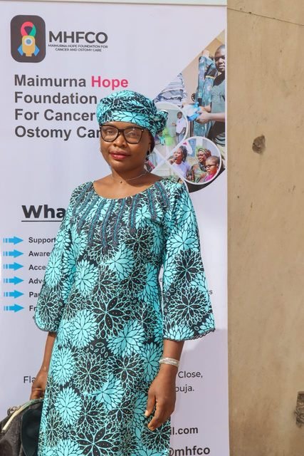 Guest at the Gombe outreach beside an MHFCO banner