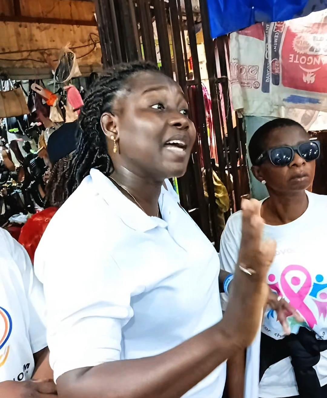Volunteer speaking with traders during the awareness outreach